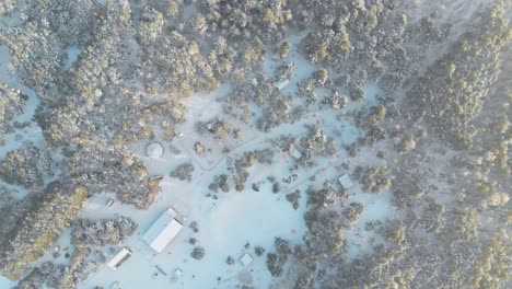 aerial overhead shot of a norwegian lost village in a forest covered with snow