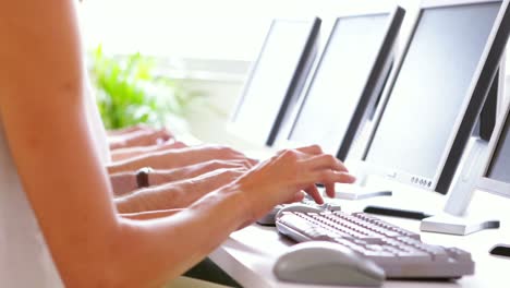 fila de trabajadores escribiendo en su escritorio