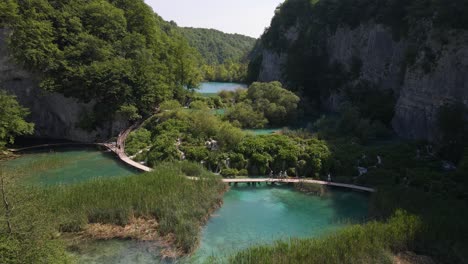 Vista-Desde-Arriba-Del-Parque-Nacional-De-Los-Lagos-De-Plitvice-Con-Plantas-Verdes-Y-Hermosos-Lagos-Y-Cascadas-Entre-Los-Que-Va-La-Gente