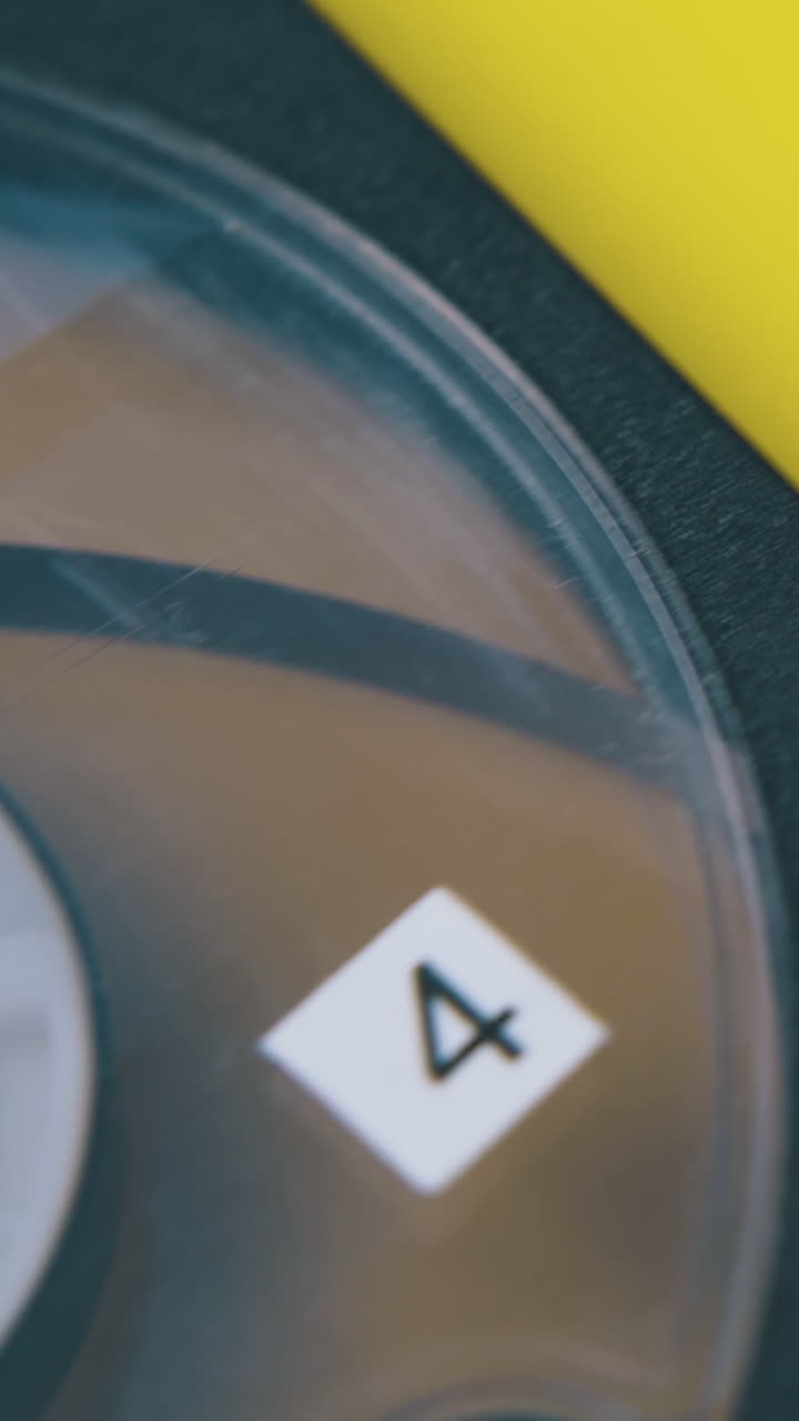 vintage compact magnetic tape cassette with number four lies on bright yellow background extreme close view