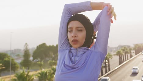 woman wearing hijab stretching outside