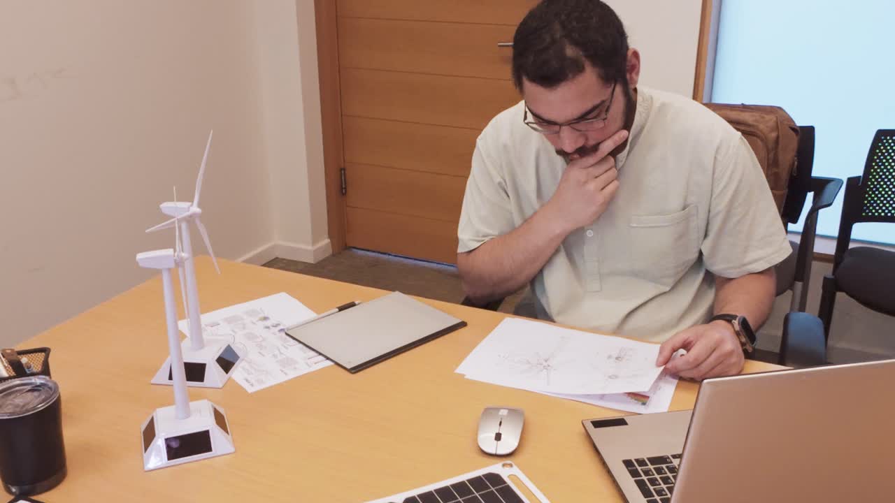 Male Engineer Problem-Solving While Reviewing Technical Drawings