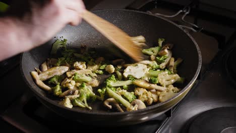 sauteing chopped broccoli, cauliflower, and mushroom for a nutritious pasta recipe