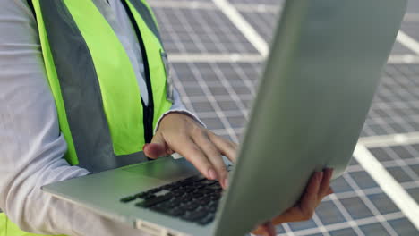 engineer working on solar panels with a laptop