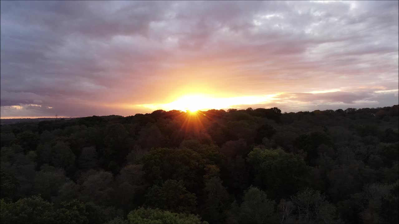 Sun, lens flare, forested area of woodland. Aerial drone shot reveals sun and beautiful British countryside.