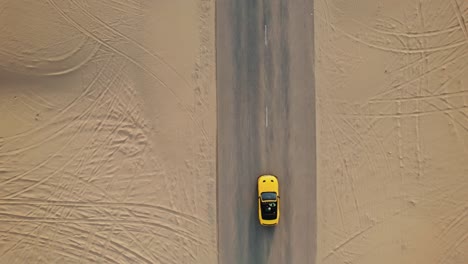 coche convertible amarillo en un camino del desierto