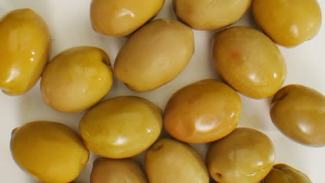 aceitunas verdes redondas en vinagre de grecia como fondo, vista de arriba. imágenes de alta calidad en 4k