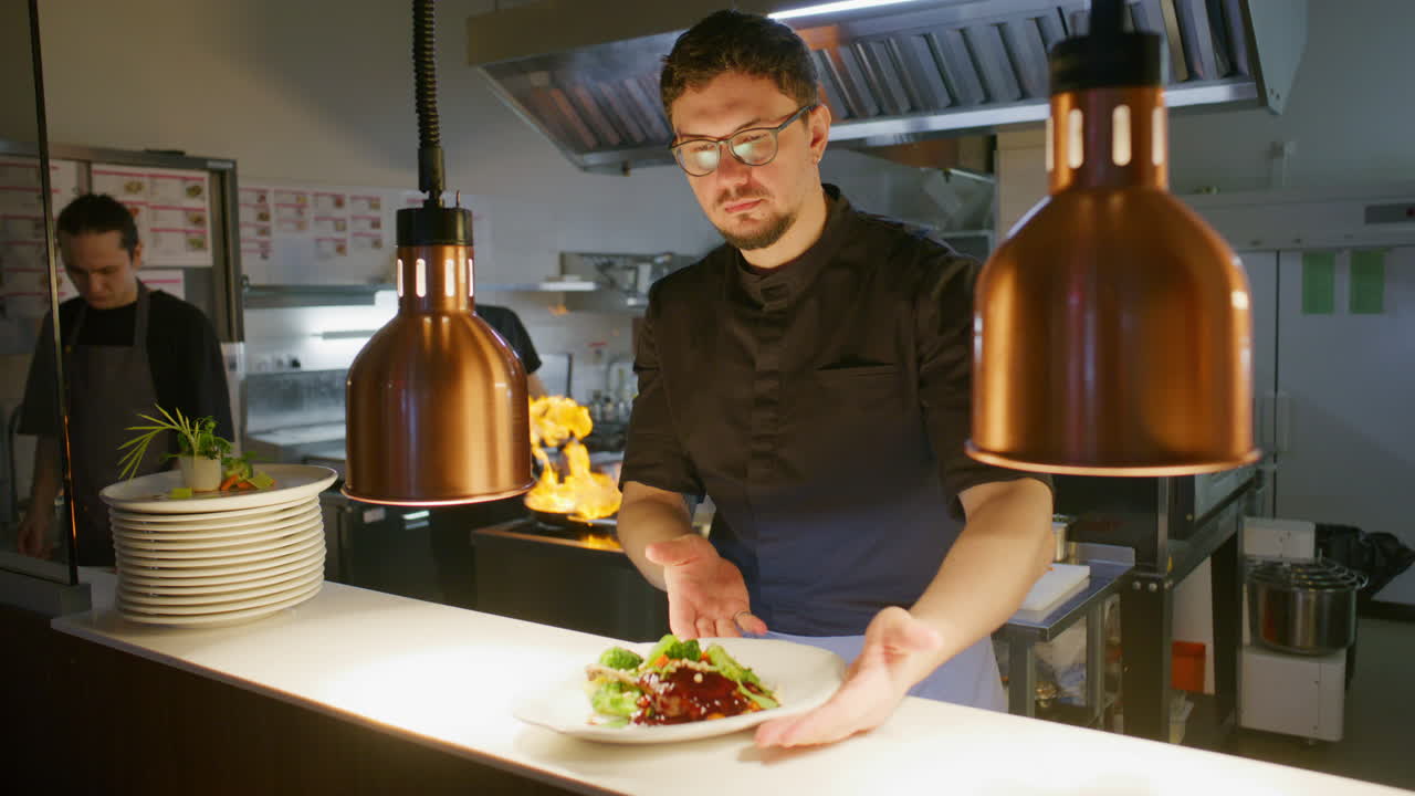 Ritratto di chef professionista che serve un piatto gourmet nella cucina di un ristorante