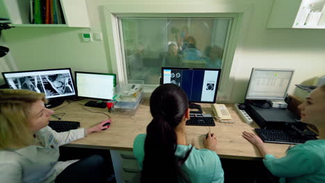 doctors looking at results of patient. in control room doctors watching mri scans results