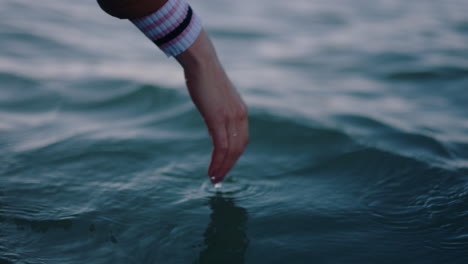 close up woman hand touching water waves splashing tourist enjoying boat ride