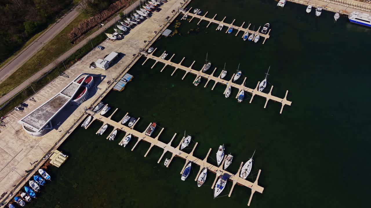 Boats docked at a marina during the day in a coastal area