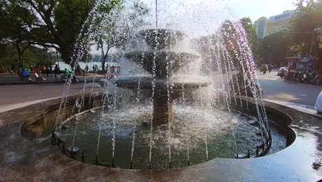 hermosa fuente en hanoi en el casco antiguo de vietnam filmada en 120 fps en un movimiento pan-up con scooter conduciendo