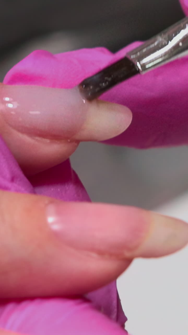Manicurist Applying Clear Gel and Red Line Design to Fingernail