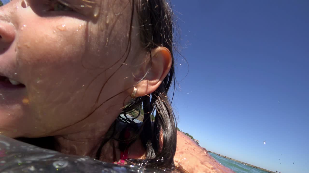 소녀는 고무 반지 위에서 바다에서 수영합니다.