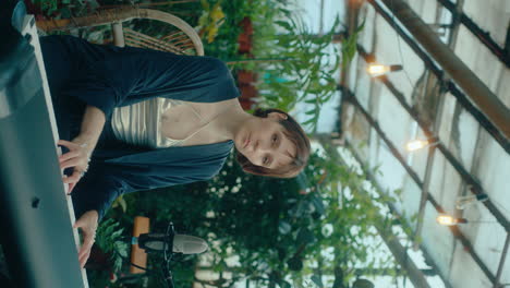 elegant woman playing keyboard and singing on camera in indoor garden