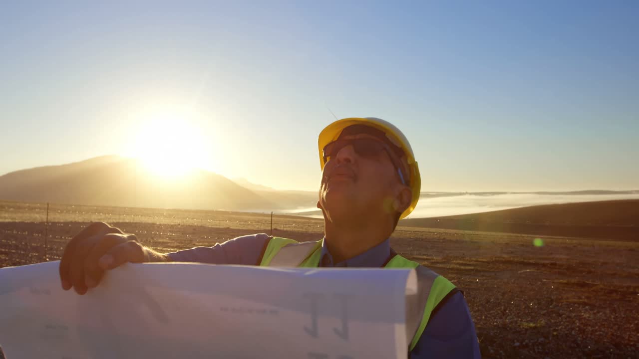 ingeniero con plano de pie en el parque eólico 4k