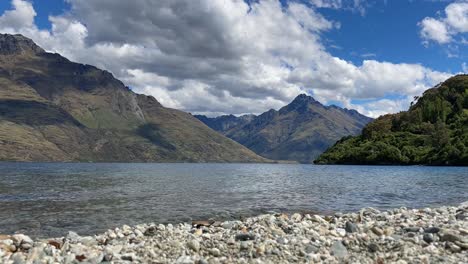 clouds passing over mountains and lake at queenstown, new zealand