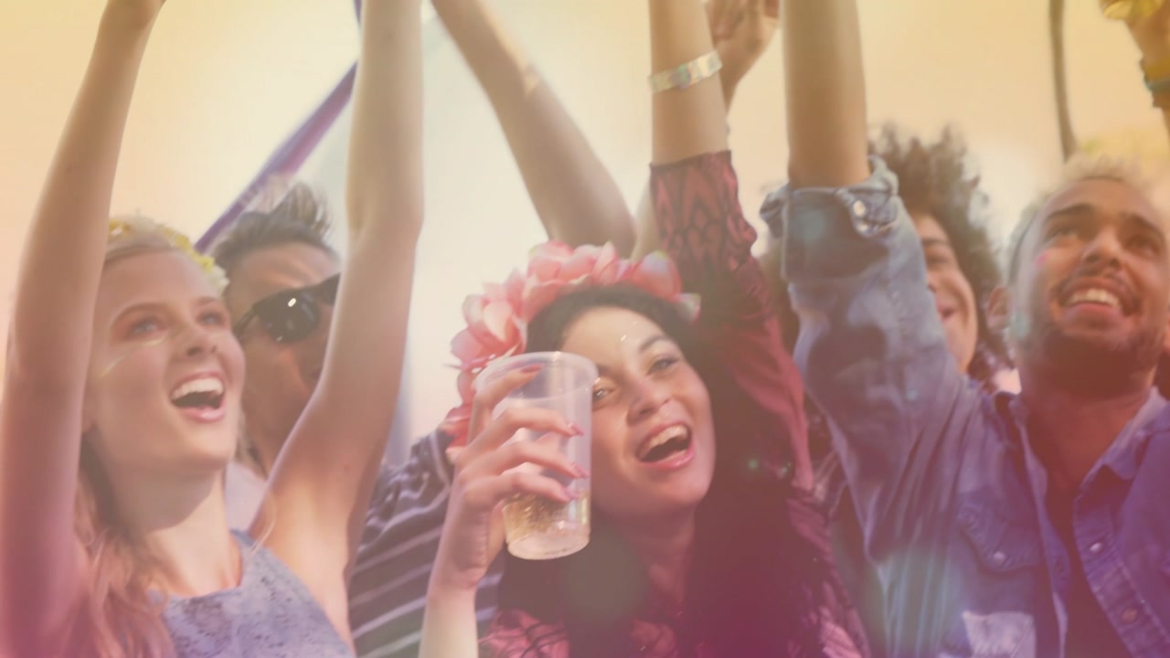 Cheering friends raising plastic cups at festival, showing floral crown as responding to beat drop
