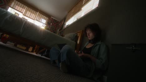 young woman working on laptop on floor in bedroom