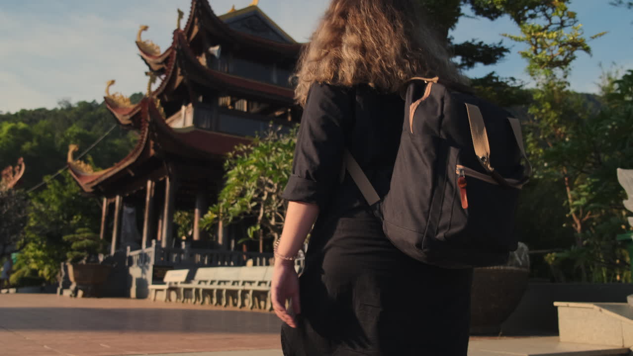 mujer con mochila visitando una pagoda