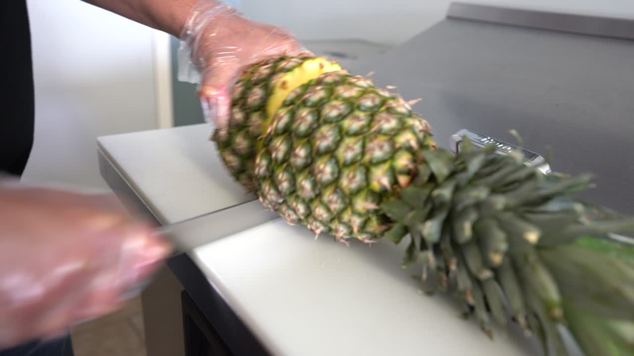 cortando una piña con un machete