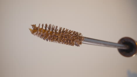 wand of pastel mascara put out of tube on beige background