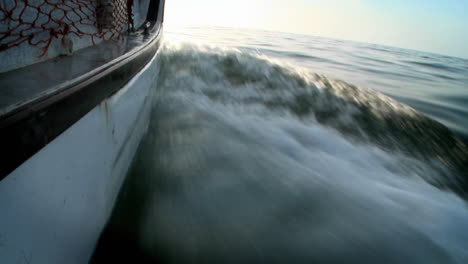 a boat moves along churning up the water