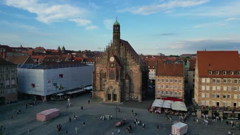 4k aerial drone video of church tower clock and on the hauptmarkt market square in nurnberg, germany - truck right