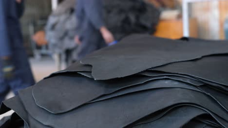 workers piling the black leather in a tannery factory in ethiopia, africa. - closeup shot
