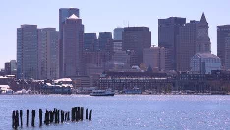 Un-Taxi-Acuático-Se-Mueve-Frente-Al-Horizonte-Del-Centro-De-La-Ciudad-Y-El-Distrito-Financiero-De-Boston,-Massachusetts