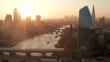 Aerial-slider-shot-over-the-river-Thames-looking-towards-city-of-London-at-sunrise