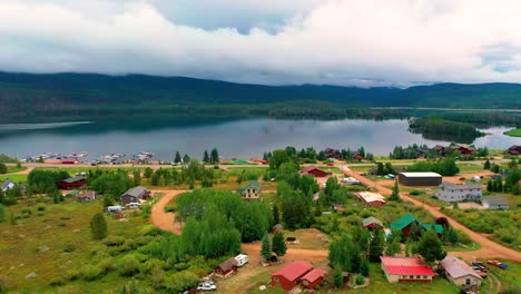 Small-Mountain-Town-Next-to-a-Lake-with-Hills-and-Clouds