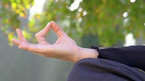 woman practicing yoga places her hand in position slowly and then opens it