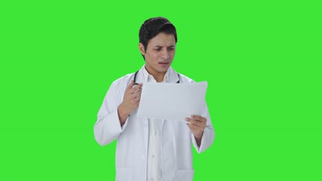 Confused-Indian-doctor-checking-medical-reports-Green-screen
