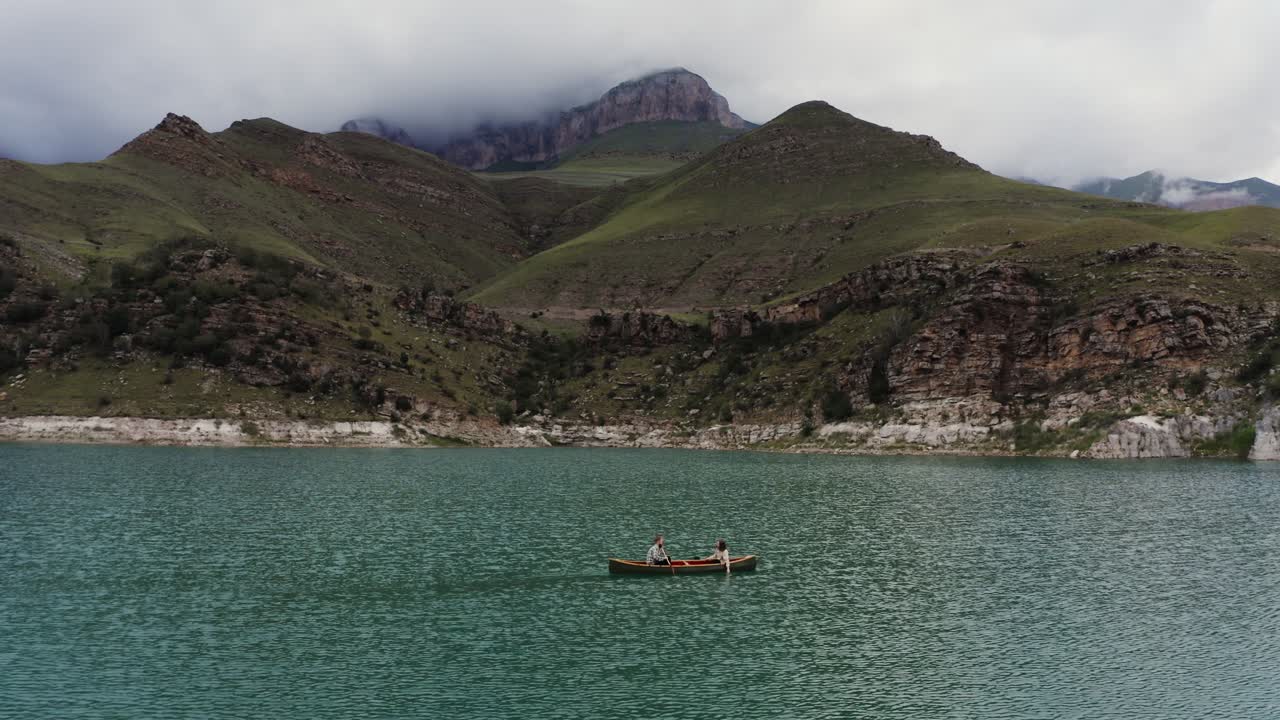 una pareja en canoa en un lago de montaña