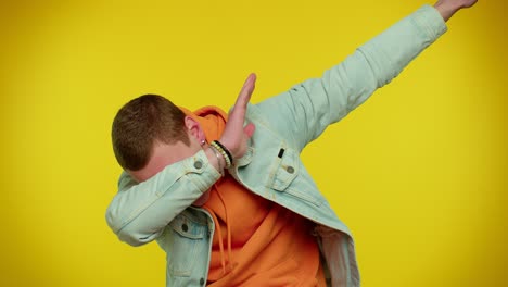 trendy cheerful man dancing and moving to rhythm, dabbing raising hands, making dubdance gesture