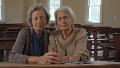 elderly women praying together
