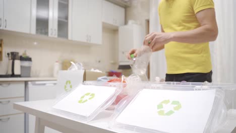 person throwing waste into recycling bins in the kitchen.