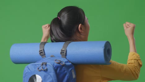 woman with backpack and yoga mat, excited expression