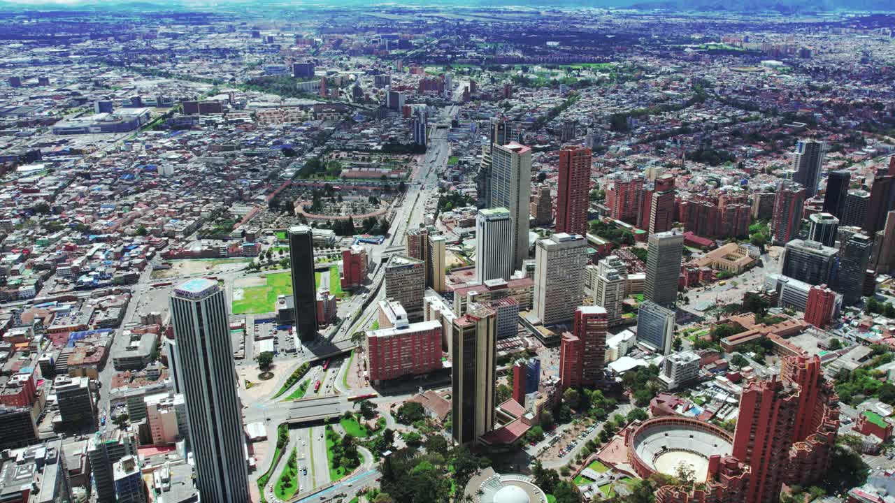 Aerial timelapse of cars weaving through buildings, with clouds drifting above, leaving their dynamic patterns over the cityscape of Bogotá