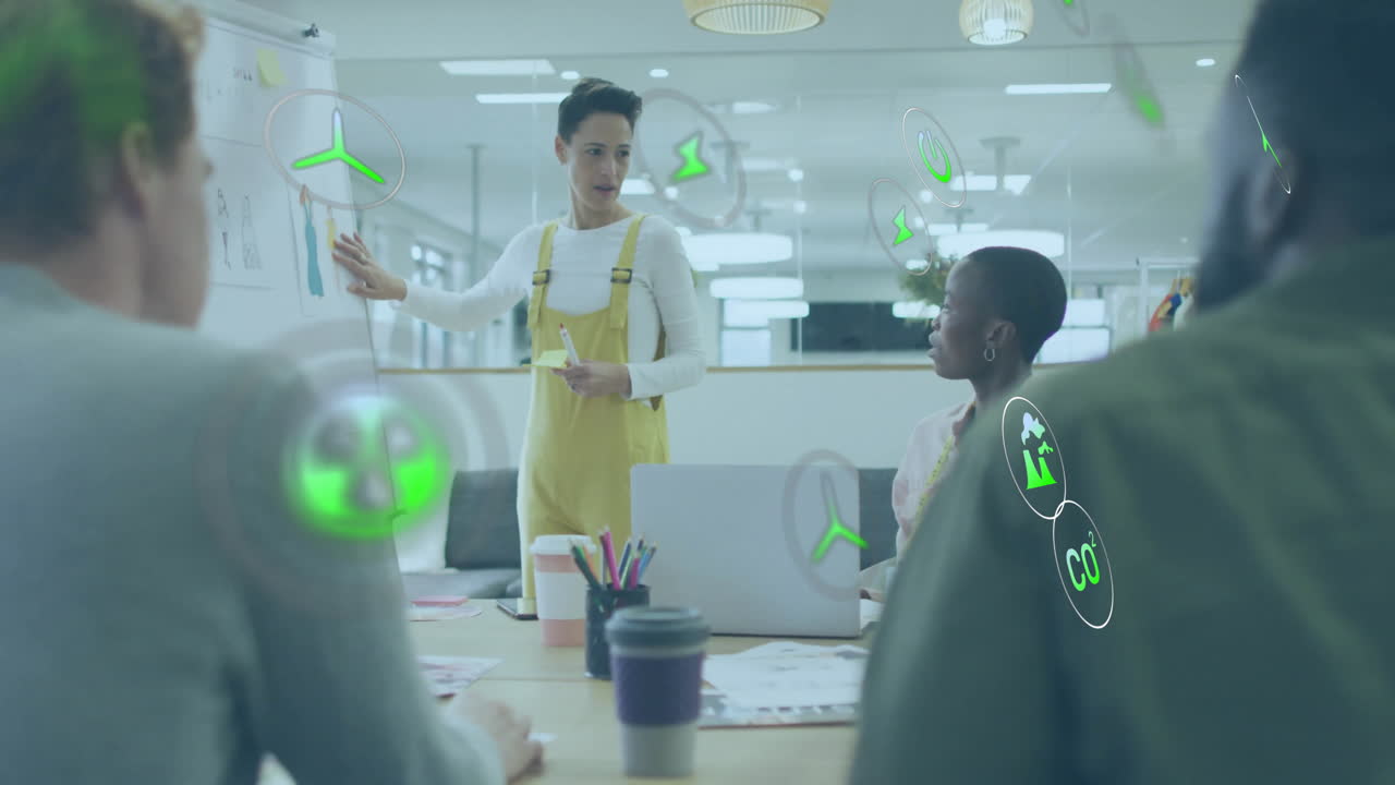 Animation of ecology icons over diverse colleagues having meeting in office