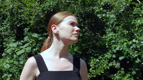 a pensive girl with red hair is looking up to the sky deep in thought and contemplation