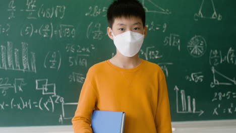 asian pupil with face mask looking at the camera.