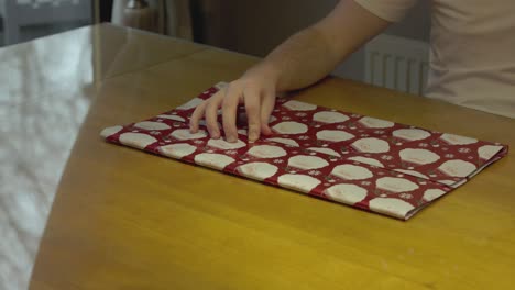 Static-shot-of-a-music-vinyl-being-wrapped-in-Christmas-paper-for-Christmas-day