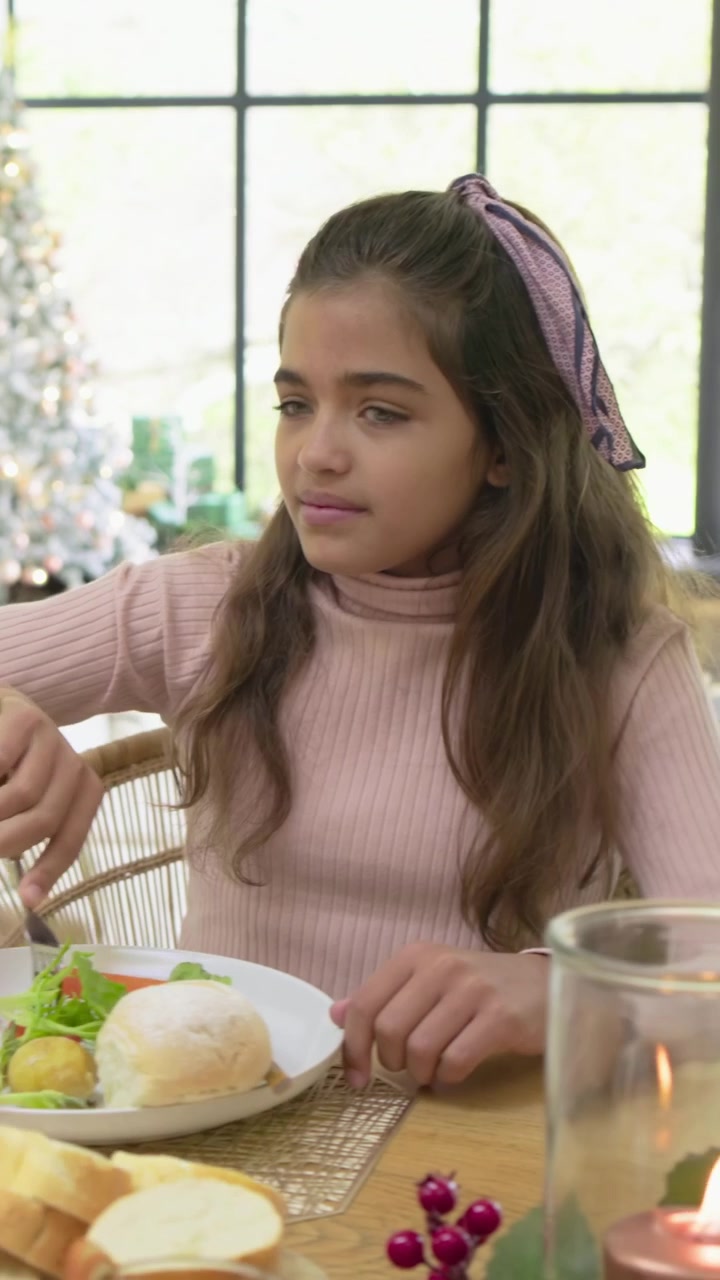 Video verticale: Offrendo un bicchiere, ragazze in magenta e rosa accettano e servono insalata a tavola a casa.