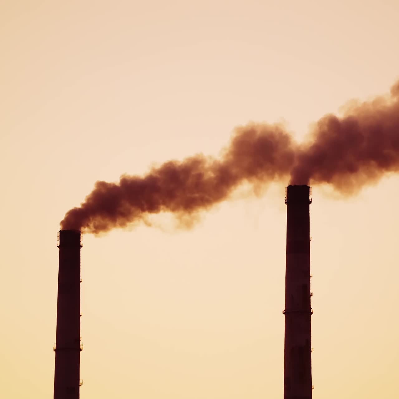 Dirty emissions are going into the air from pipes. Chemical smoke pollute the atmosphere of the evening sky. Close-up.