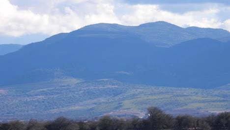 captivating stock footage: witness a majestic green mountain as fast-moving clouds cast mesmerizing shadows