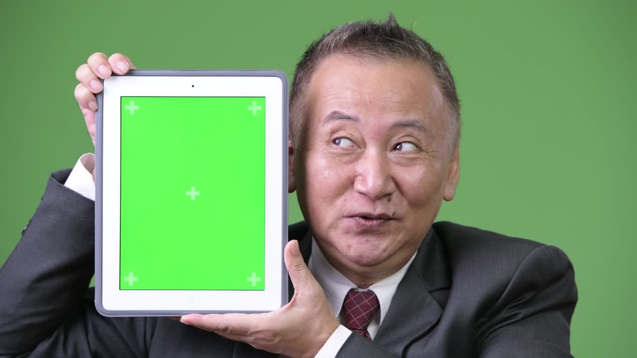 디지털 태블릿을 보여주는 성숙한 일본 사업가