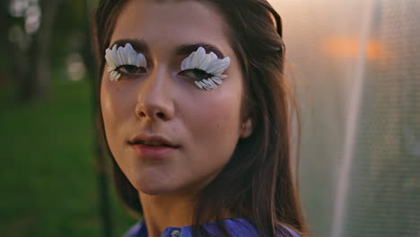 woman face floral makeup closeup. portrait fashion model with petal eyelashes