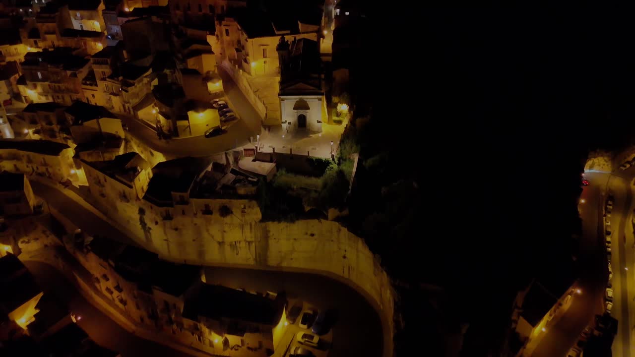 Night drone flight over curvy roads in Ragusa revealing the city